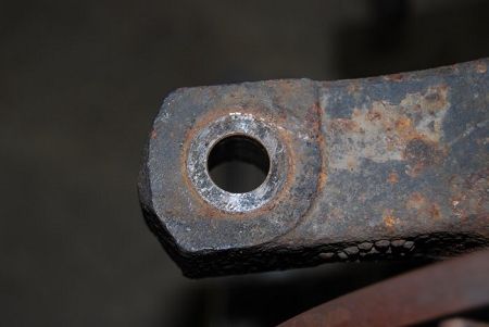 Close-up of a steering arm eye drilled out for a larger tapered stud