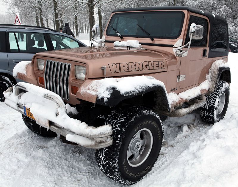 Jeep YJ Wrangler with round fender flares parked in snow
